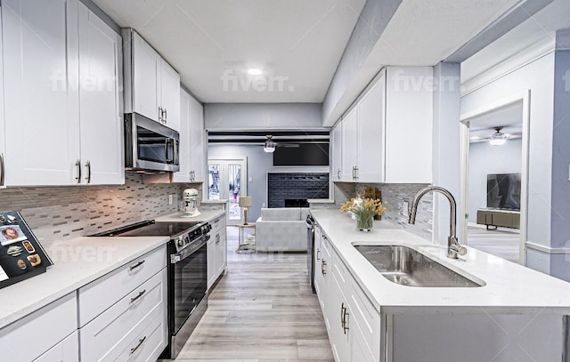 kitchen with white cabinetry, ceiling fan, stainless steel appliances, and sink