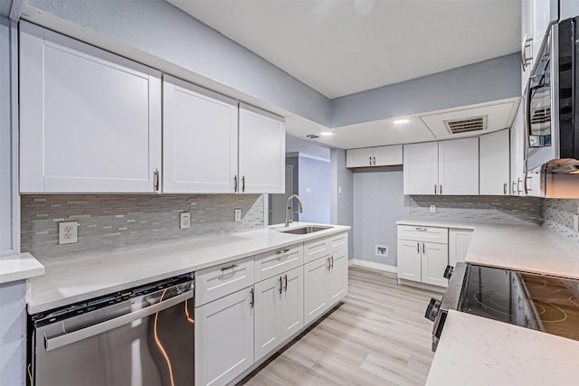 kitchen with white cabinetry, appliances with stainless steel finishes, sink, and backsplash