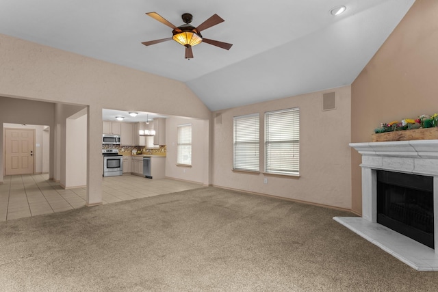 unfurnished living room with lofted ceiling, light colored carpet, and ceiling fan