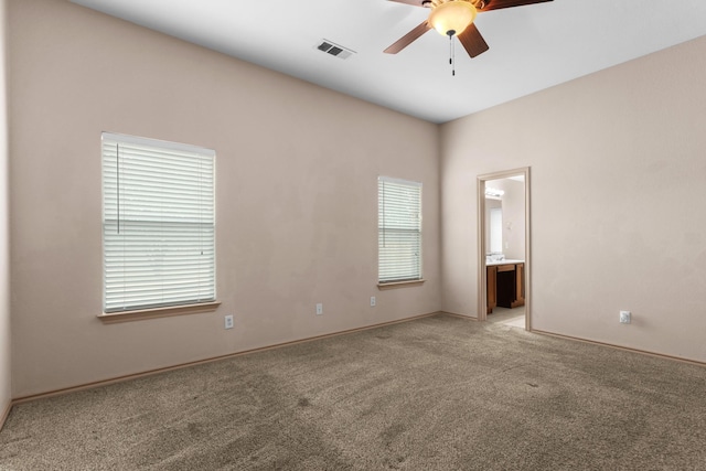 spare room with ceiling fan and light colored carpet