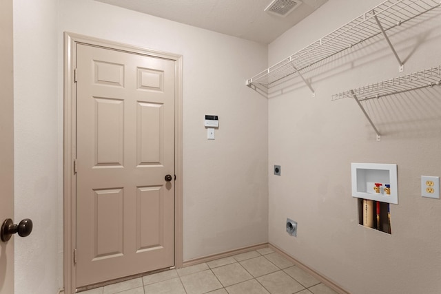 clothes washing area featuring light tile patterned flooring, hookup for an electric dryer, and hookup for a washing machine