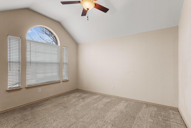 empty room with vaulted ceiling, light colored carpet, and ceiling fan