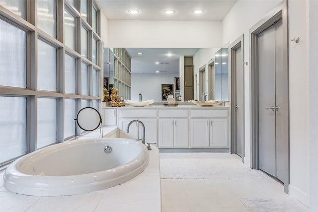 bathroom featuring vanity, tiled tub, and tile patterned floors