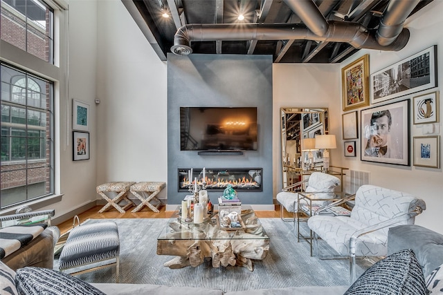 living room with a high ceiling and hardwood / wood-style floors