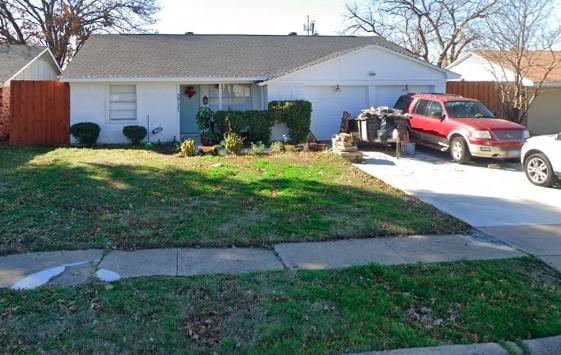 ranch-style home with a garage and a front lawn