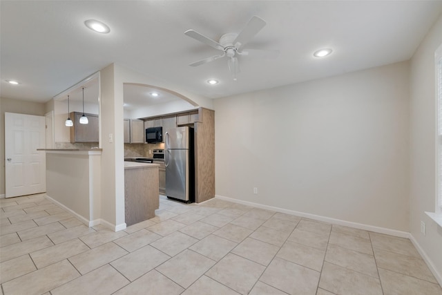 kitchen featuring appliances with stainless steel finishes, decorative light fixtures, tasteful backsplash, ceiling fan, and kitchen peninsula