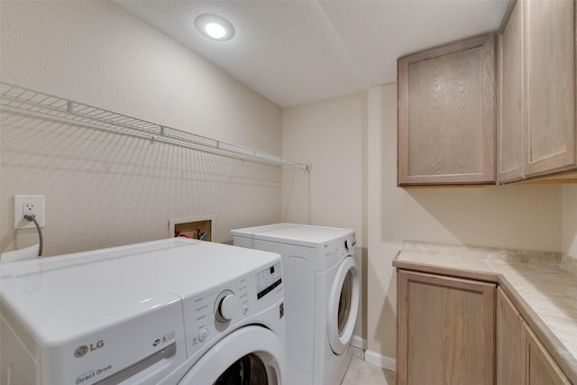 clothes washing area featuring cabinets and washing machine and clothes dryer