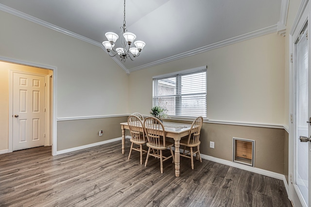 dining area with an inviting chandelier, ornamental molding, vaulted ceiling, and hardwood / wood-style floors