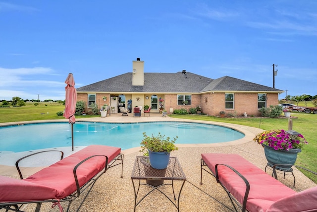 view of pool featuring a lawn and a patio area