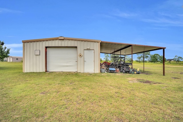 view of outbuilding featuring a garage, a lawn, and a carport