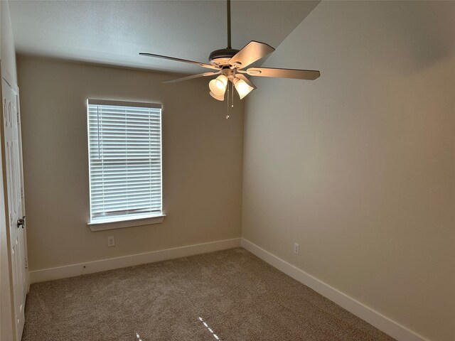 carpeted spare room with ceiling fan