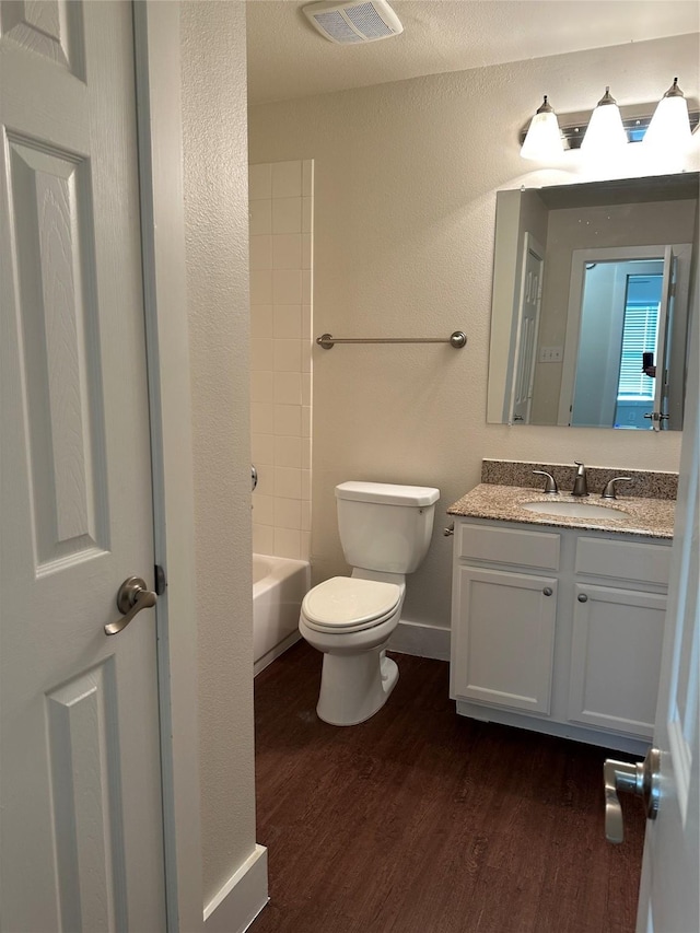 full bathroom with vanity, hardwood / wood-style floors,  shower combination, and toilet