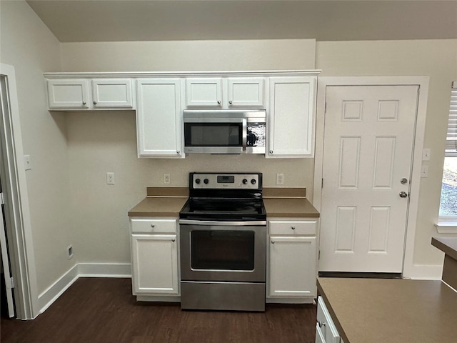 kitchen with dark wood-type flooring, stainless steel appliances, and white cabinets