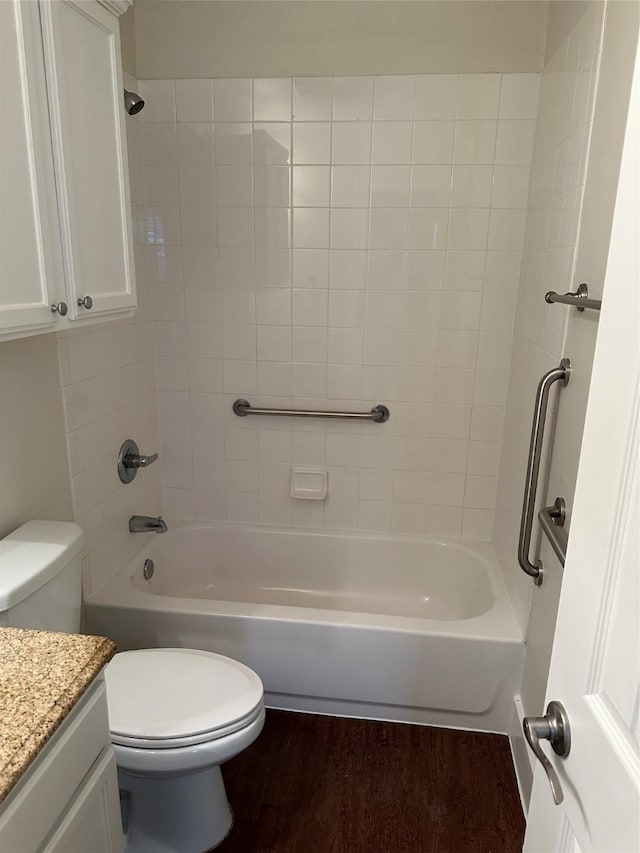 full bathroom featuring hardwood / wood-style flooring, vanity, tiled shower / bath combo, and toilet