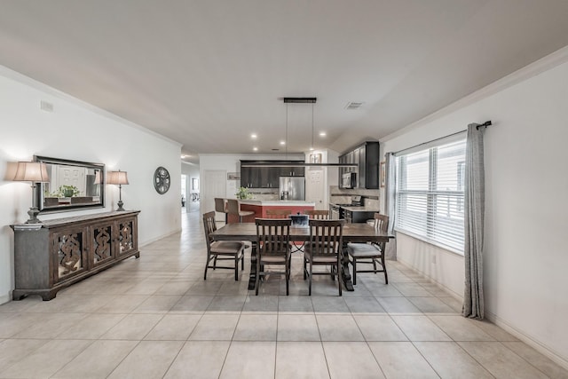 dining space with ornamental molding and light tile patterned flooring