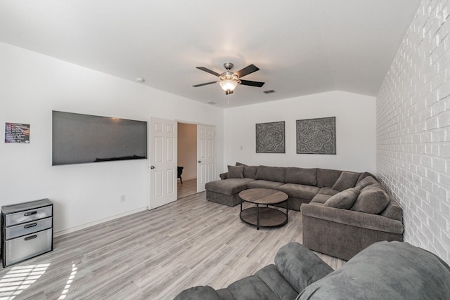 living room featuring brick wall, lofted ceiling, ceiling fan, and light hardwood / wood-style flooring