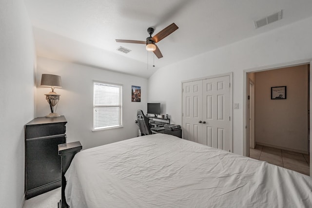 bedroom with light tile patterned flooring, ceiling fan, and a closet