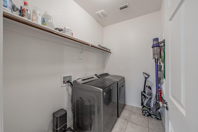 laundry room featuring independent washer and dryer and light tile patterned floors