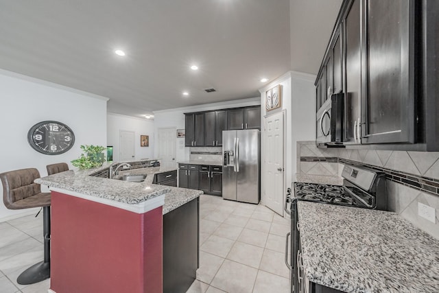 kitchen featuring light tile patterned flooring, sink, a kitchen breakfast bar, stainless steel appliances, and light stone countertops