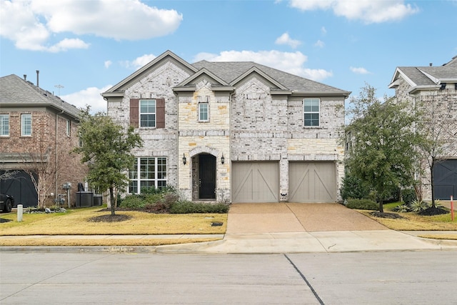 view of front of home with a garage, central AC unit, and a front lawn