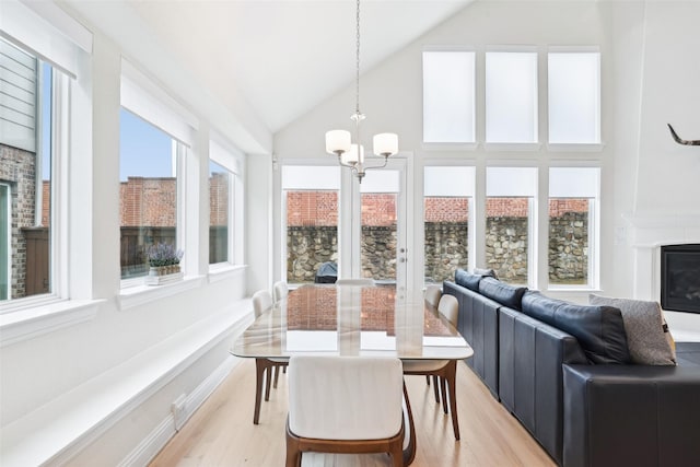 sunroom featuring an inviting chandelier and vaulted ceiling