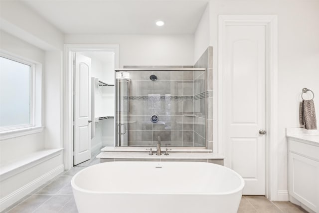 bathroom featuring independent shower and bath, vanity, and tile patterned flooring