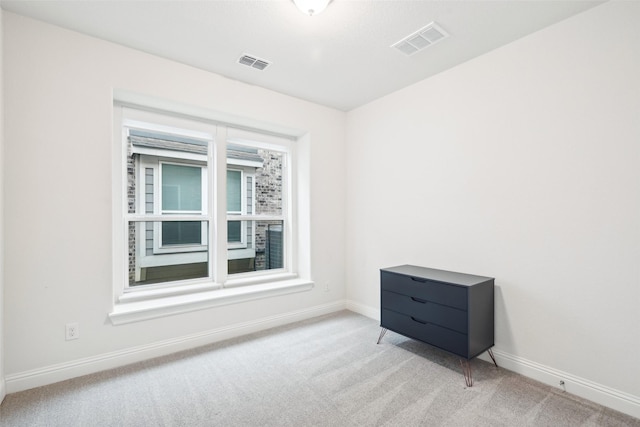 spare room featuring light colored carpet