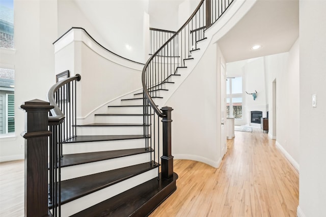 stairs featuring wood-type flooring and a towering ceiling