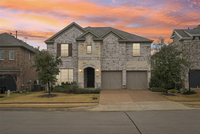 french country inspired facade featuring central AC, a garage, and a lawn