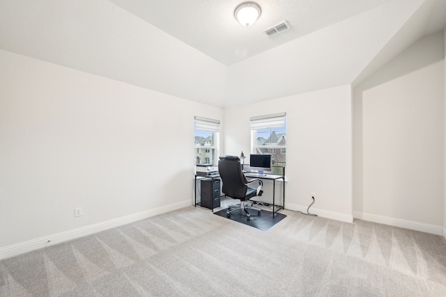 home office featuring light colored carpet and vaulted ceiling