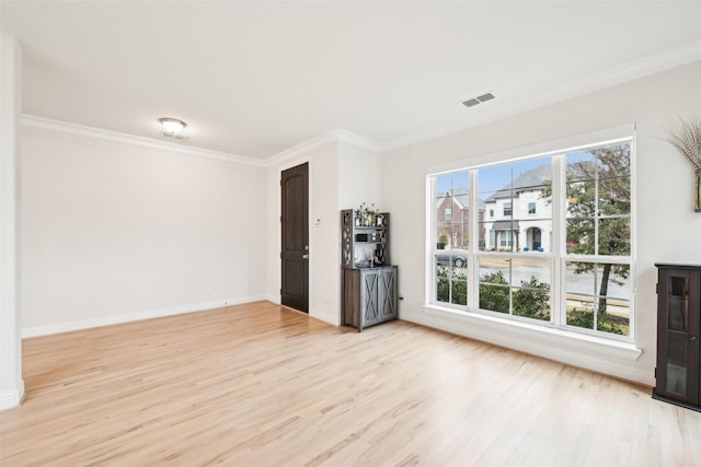 unfurnished living room with crown molding and light hardwood / wood-style flooring