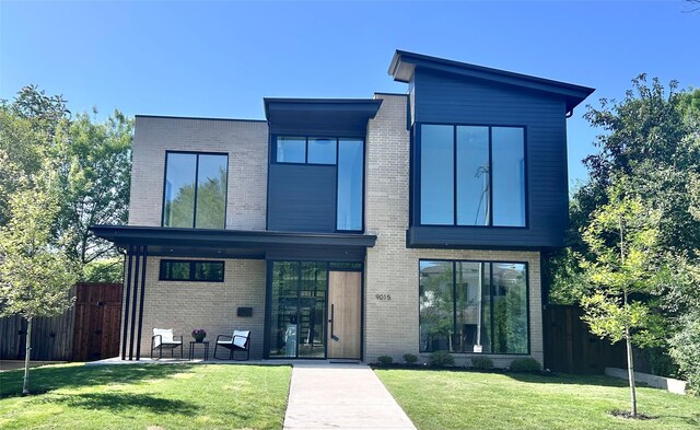 rear view of property featuring brick siding, fence, and a patio area
