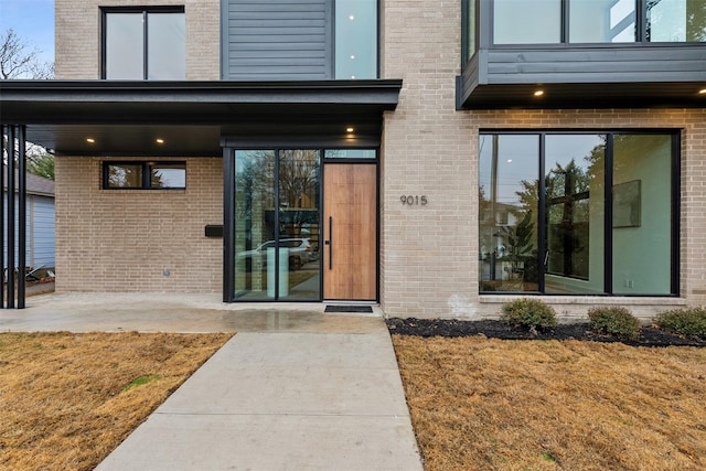 property entrance featuring a lawn and a patio