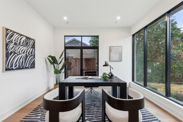 spare room with baseboards and light wood-type flooring