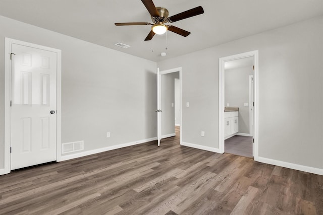 unfurnished bedroom featuring hardwood / wood-style floors, ceiling fan, and ensuite bathroom