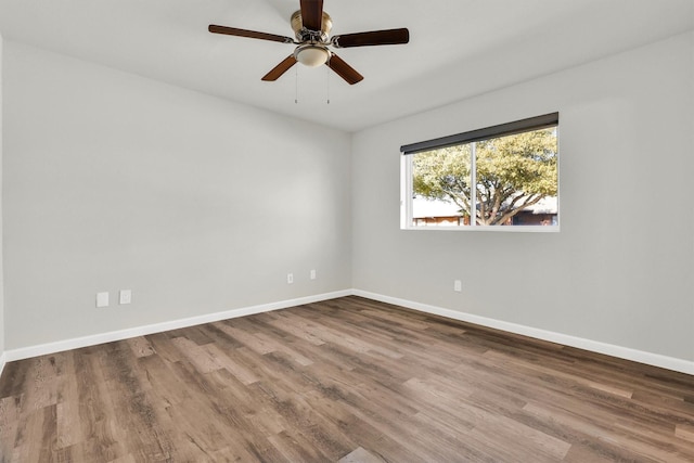 empty room with hardwood / wood-style floors and ceiling fan