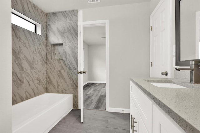 bathroom with vanity and tiled shower / bath