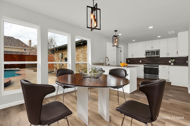 dining space featuring sink and light hardwood / wood-style flooring