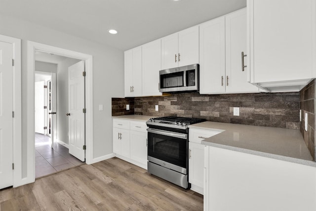 kitchen with white cabinetry, tasteful backsplash, and stainless steel appliances