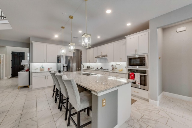 kitchen featuring sink, a center island with sink, white cabinets, and appliances with stainless steel finishes