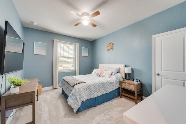 carpeted bedroom with ceiling fan and a textured ceiling