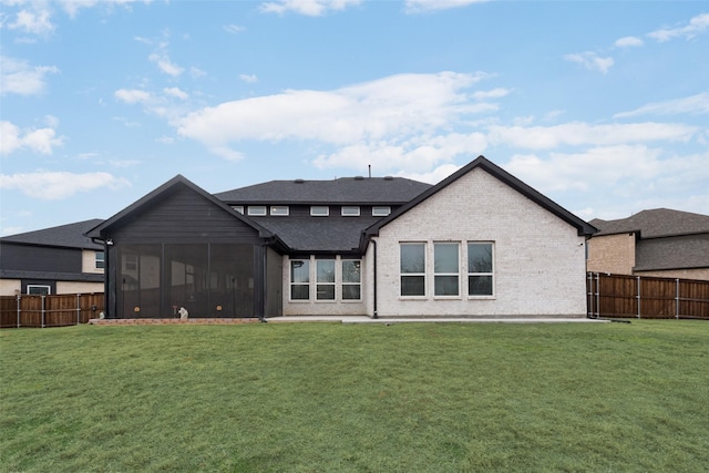 back of house with a lawn and a sunroom