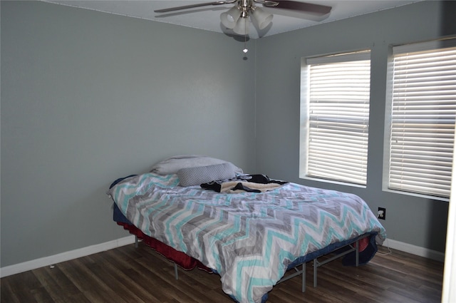 bedroom with dark hardwood / wood-style flooring and ceiling fan