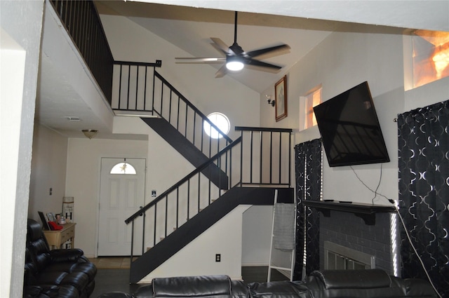 staircase featuring ceiling fan and high vaulted ceiling