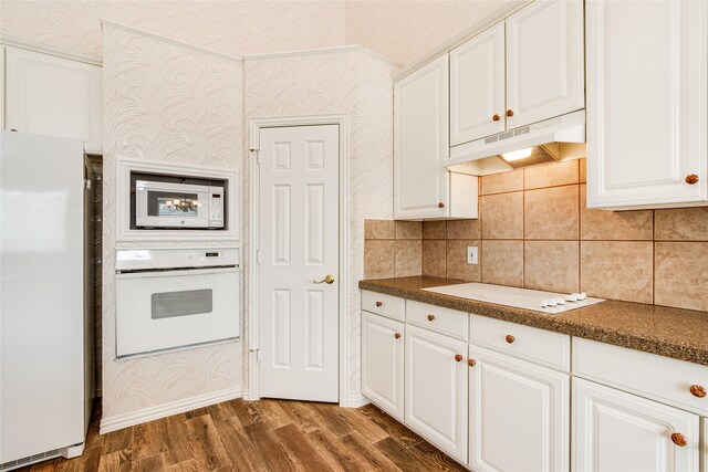 kitchen with white appliances, dark hardwood / wood-style floors, and white cabinets