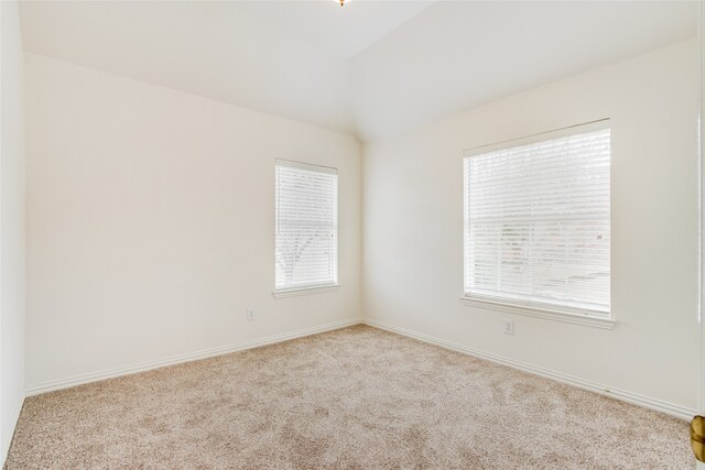 carpeted empty room featuring lofted ceiling and a healthy amount of sunlight