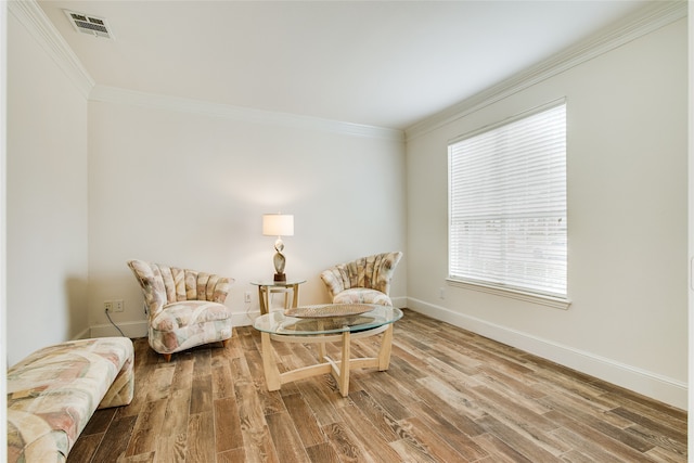 living area with crown molding and wood-type flooring