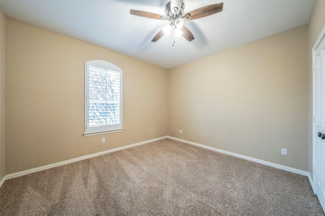 carpeted spare room featuring ceiling fan