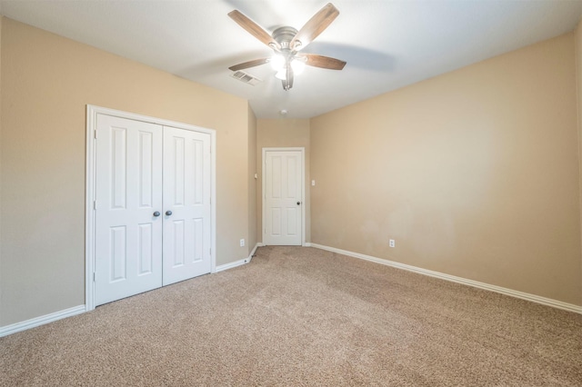 unfurnished bedroom featuring carpet, ceiling fan, and a closet