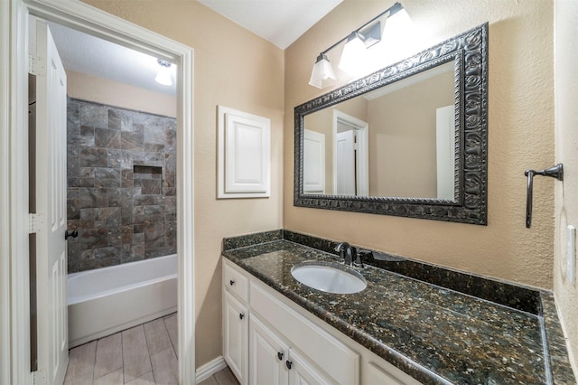 bathroom featuring vanity and tiled shower / bath